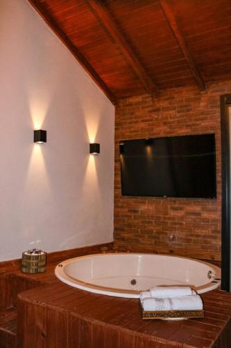 a large bathroom with a tub and a television at Império Cabanas in Urubici