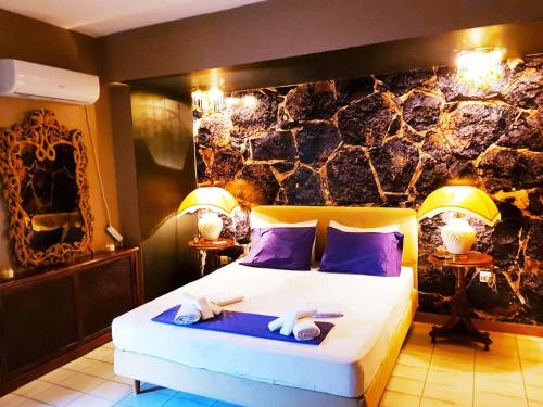 a bedroom with a large bed with purple pillows at Kouro's private room! in Piraeus