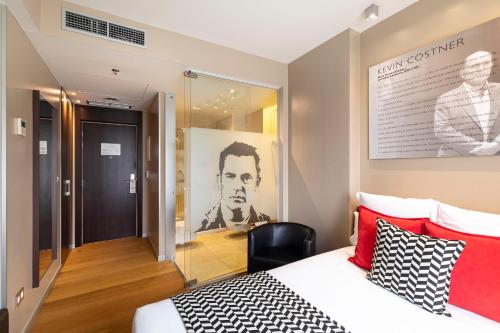 a hotel room with a bed and a chair and a window at Hotel Zinema7 in Donostia-San Sebastián