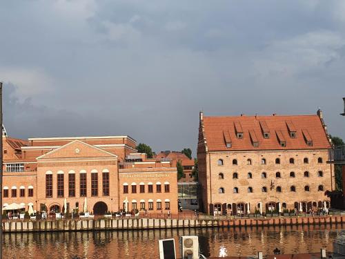 a group of buildings next to a body of water at Apartament nad Motławą in Gdańsk