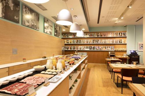 a buffet line in a restaurant with tables and chairs at Hotel Zinema7 in Donostia-San Sebastián