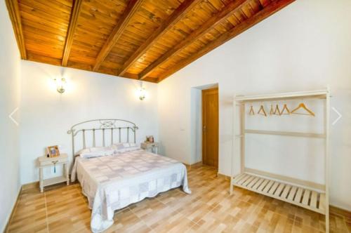 - une chambre avec un lit et un plafond en bois dans l'établissement La casa del bisa, à Genovés