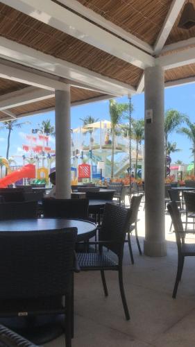 a restaurant with tables and chairs and a water park at Salinas Exclusive Resort in Salinópolis