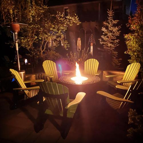 a firepit with chairs and a table with a fire burns at Explorer House Bed & Breakfast in Niagara on the Lake