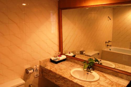 a bathroom with a sink and a mirror and a tub at Phuket Golden Sand Inn - SHA Extra Plus in Karon Beach