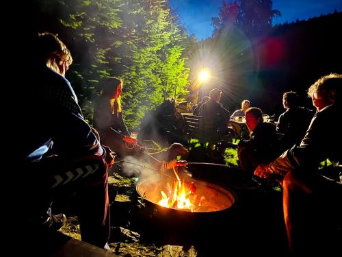 a group of people sitting around a camp fire at Hotel Slatina in Lipova Lazne