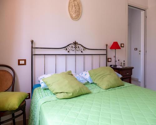 - une chambre avec un lit vert et 2 oreillers dans l'établissement La casa di Flora, à Loreto Aprutino