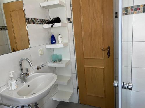 een badkamer met een wastafel, een spiegel en een douche bij Haus Seefrieden in Clausthal-Zellerfeld
