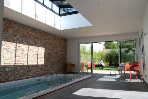 een zwembad in een kamer met een bakstenen muur bij Appart hôtel & Spa La Villa du Port in Vannes