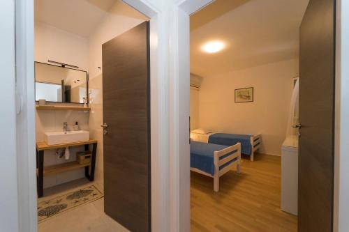 a bathroom with a sink and a bed in a room at Apartments Bisko in Prizba