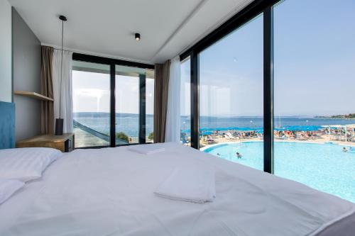 a bedroom with a bed and a view of a pool at Hotel Millenium deluxe in Selce