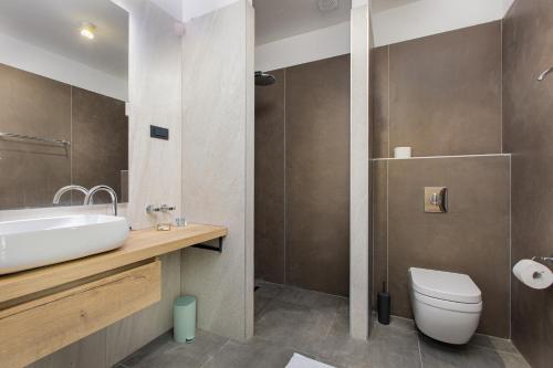 a bathroom with a sink and a toilet at Hotel Millenium deluxe in Selce