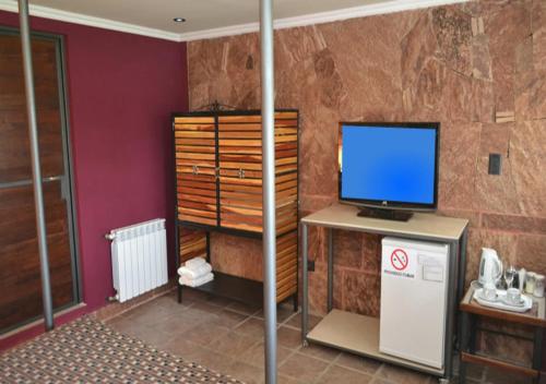 a room with a desk with a computer and a television at Cabañas San Lorenzo in San Lorenzo