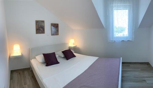a bedroom with a large white bed with two pillows at Villa OpuZEN in Opuzen