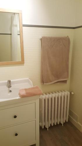 La salle de bains est pourvue d'un lavabo, d'un miroir et d'une serviette. dans l'établissement Chambres d'hôtes au centre de Guémené-sur-Scorff, à Guéméné-sur-Scorff