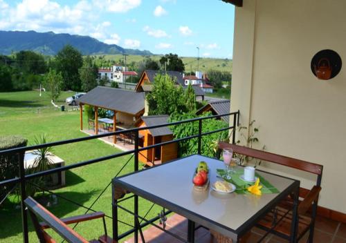 a table on a balcony with a view of a yard at Cabañas San Lorenzo in San Lorenzo