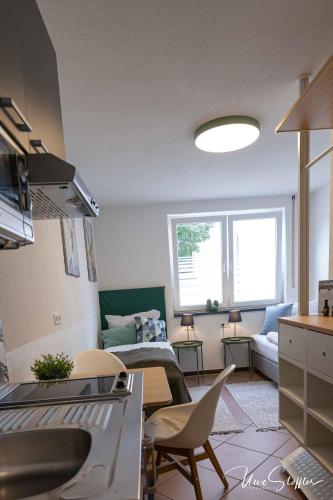 a living room with a kitchen and a living room with a couch at Sali Homes - GaesteHaus Lamm Obersulm in Obersulm
