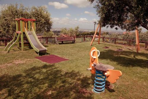 a playground with two swings and a slide at La Vista Agriturismo Boutique in Ariccia
