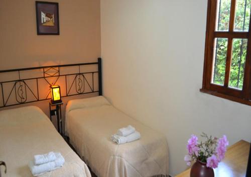 a room with two beds and a lamp and a window at Cabañas San Lorenzo in San Lorenzo