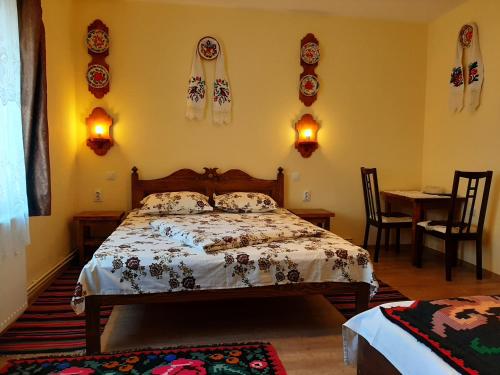 a bedroom with a bed and a table at Pension Casa Muntean in Vadu Izei