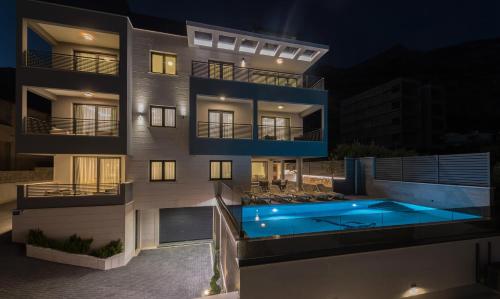 a building with a swimming pool at night at Villa Lovric in Makarska