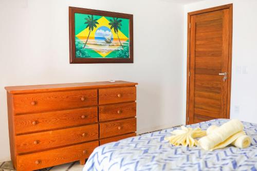 a bedroom with a bed and a dresser and a painting at Qavi - Leuchtturm House #ParaisoDoBrasil in Parnamirim