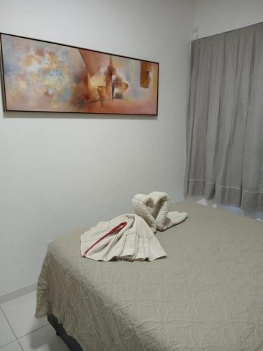 a bed in a room with a painting on the wall at Lazer nas Alturas in Vila Velha