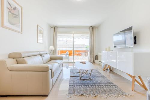 un salon blanc avec un canapé et une table dans l'établissement Stylish 1-Bedroom Apartment Close to Beaches, à Cannes