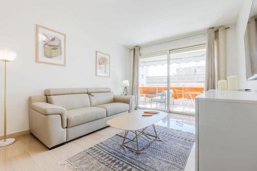 un salon avec un canapé et une table dans l'établissement Stylish 1-Bedroom Apartment Close to Beaches, à Cannes