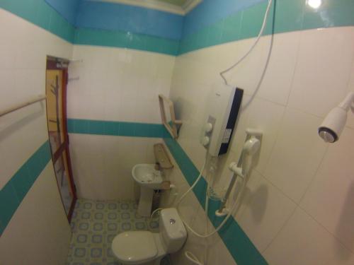 y baño con 2 aseos y ducha. en Jail Break Surf Inn, en Himmafushi