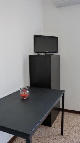 a black table with a bowl in front of a tv at L'Altra Modica Locazione Turistica in Modica