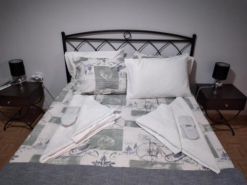 a bed with a black and white comforter and pillows at Perikleous Apartment in Athens