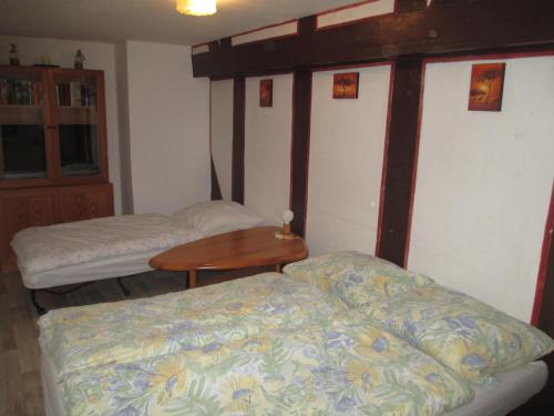 a bedroom with two beds and a wooden table at Alsfelder Apartment in Alsfeld