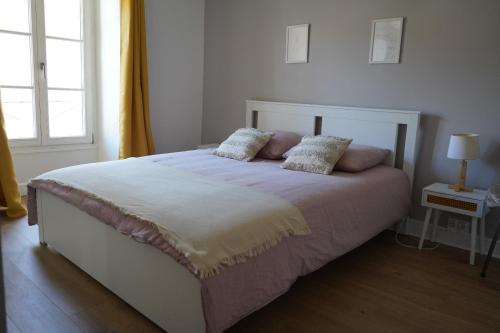 a bedroom with a bed with two pillows on it at un dimanche chez Julie chambre Célestine in Parthenay