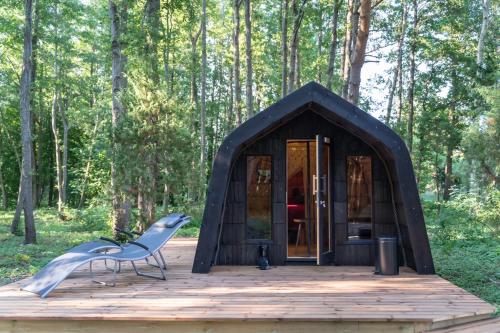 een zwarte tent met een stoel op een houten terras bij Hundi kämping in Hiiessaare