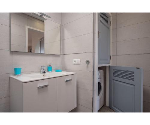 Un baño con lavabo y lavadora. en Puerto Chico Y, en Playa Blanca