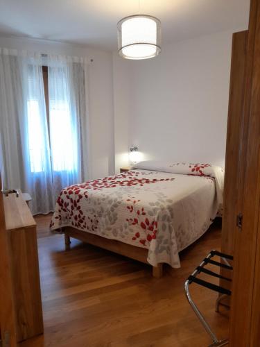 a bedroom with a bed with a red and white blanket at Apartamentos Doctor Fleming in Jaraiz de la Vera