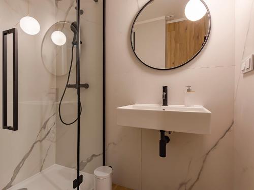 łazienka z umywalką i lustrem w obiekcie VacationClub – Sosnowa 4 Apartament 36 w mieście Mielno