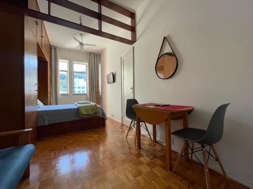 sypialnia z łóżkiem, stołem i krzesłami w obiekcie Studio Buckingham Palace w mieście Teresópolis