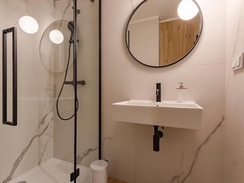 a bathroom with a sink and a mirror at VacationClub – Sosnowa 4 Apartament 43 in Mielno