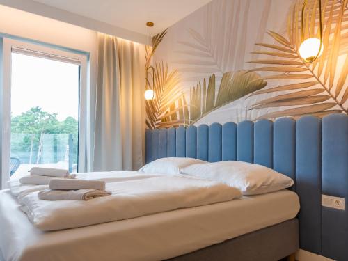 1 dormitorio con 2 camas y ventana grande en VacationClub – Sosnowa 4 Apartament 43 en Mielno