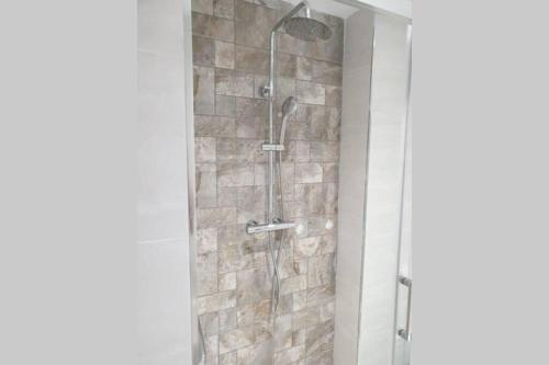 y baño con ducha y pared de piedra. en Apartamento recién reformado en Barakaldo, en Barakaldo
