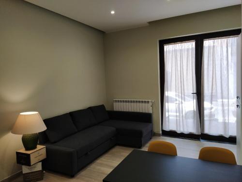 - un salon avec un canapé noir et une table dans l'établissement Gelsonero Apartments, à Ragalna
