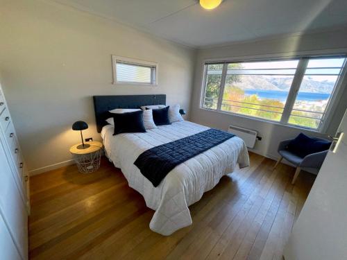 a bedroom with a bed and a large window at Villa Queenstown in Queenstown