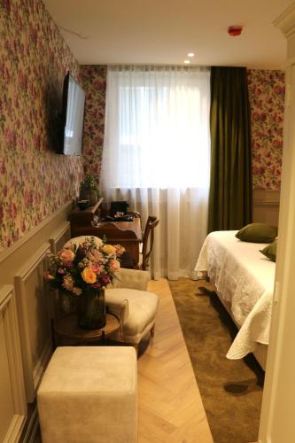 a room with a bedroom with a bed and a couch at Grand Hotel Normandy by CW Hotel Collection in Bruges