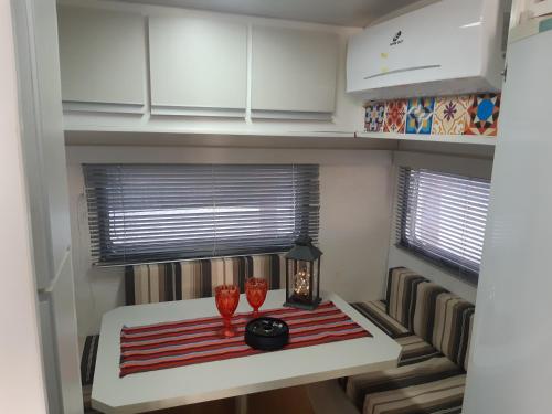 a small kitchen with a table with two vases on it at Trailer novo completo. in Bagé