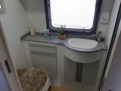 ein Bad mit einem Waschbecken und einem WC in der Unterkunft Trailer novo completo. in Bagé