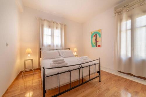 um quarto com uma cama com lençóis brancos e uma janela em Seaview Stylish Flat in Andros - walk to beach em Andros