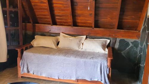 a wooden bed with two pillows on top of it at Cabañas kymey in San Clemente del Tuyú