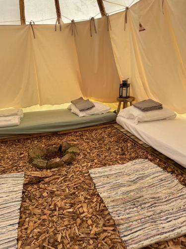 um quarto com duas camas numa tenda em Terra-Tipike, Tipi à la ferme entre Terre et Mer em Trébry